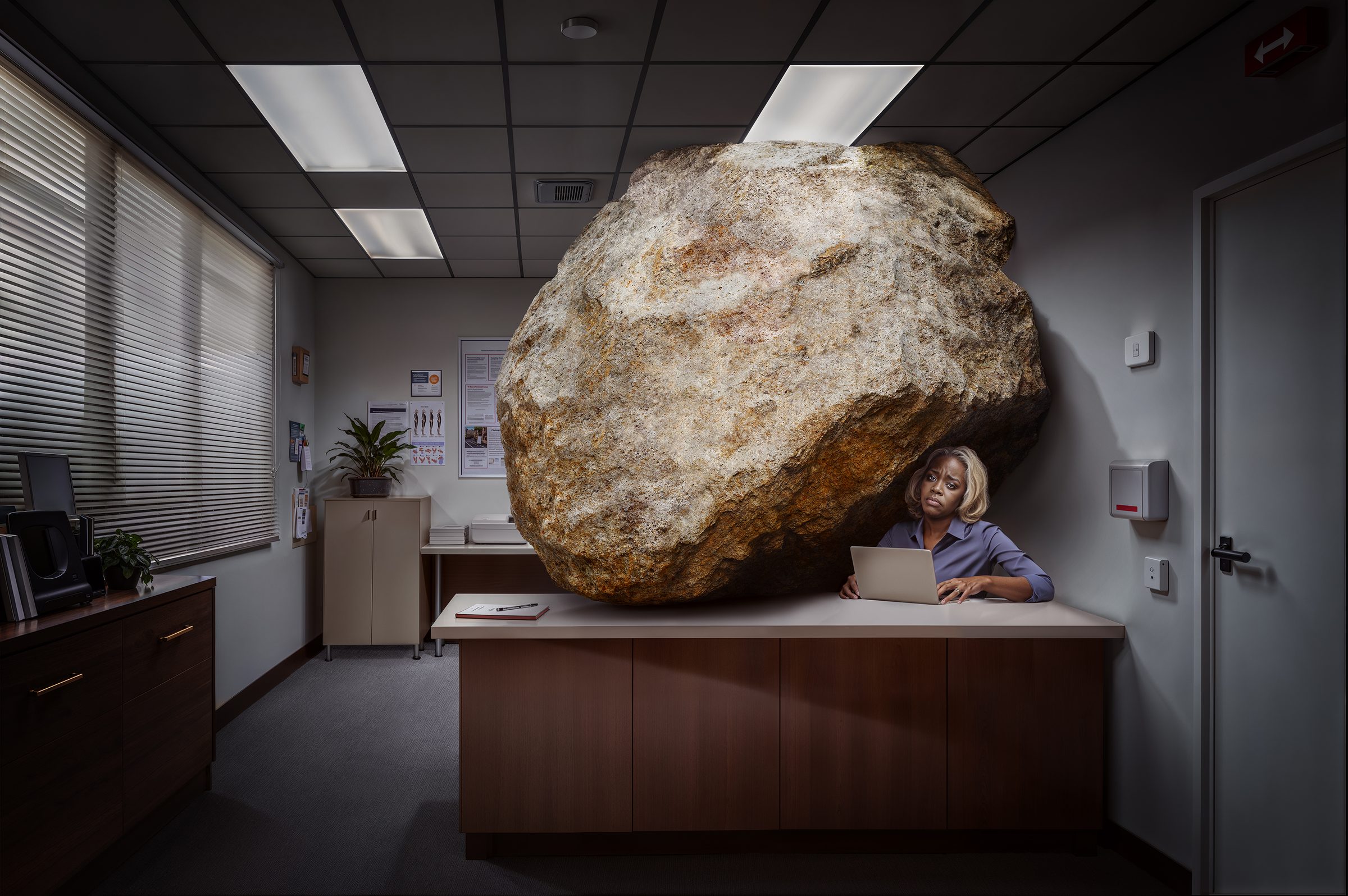 Hallmark A.i: a woman at her desk squeezed by a giant boulder
