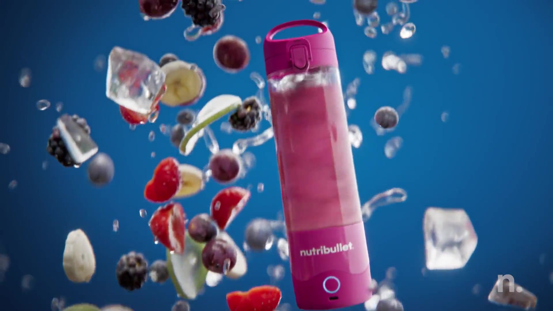 Pink Nutribullet Portable among flying CGI fruit on blue