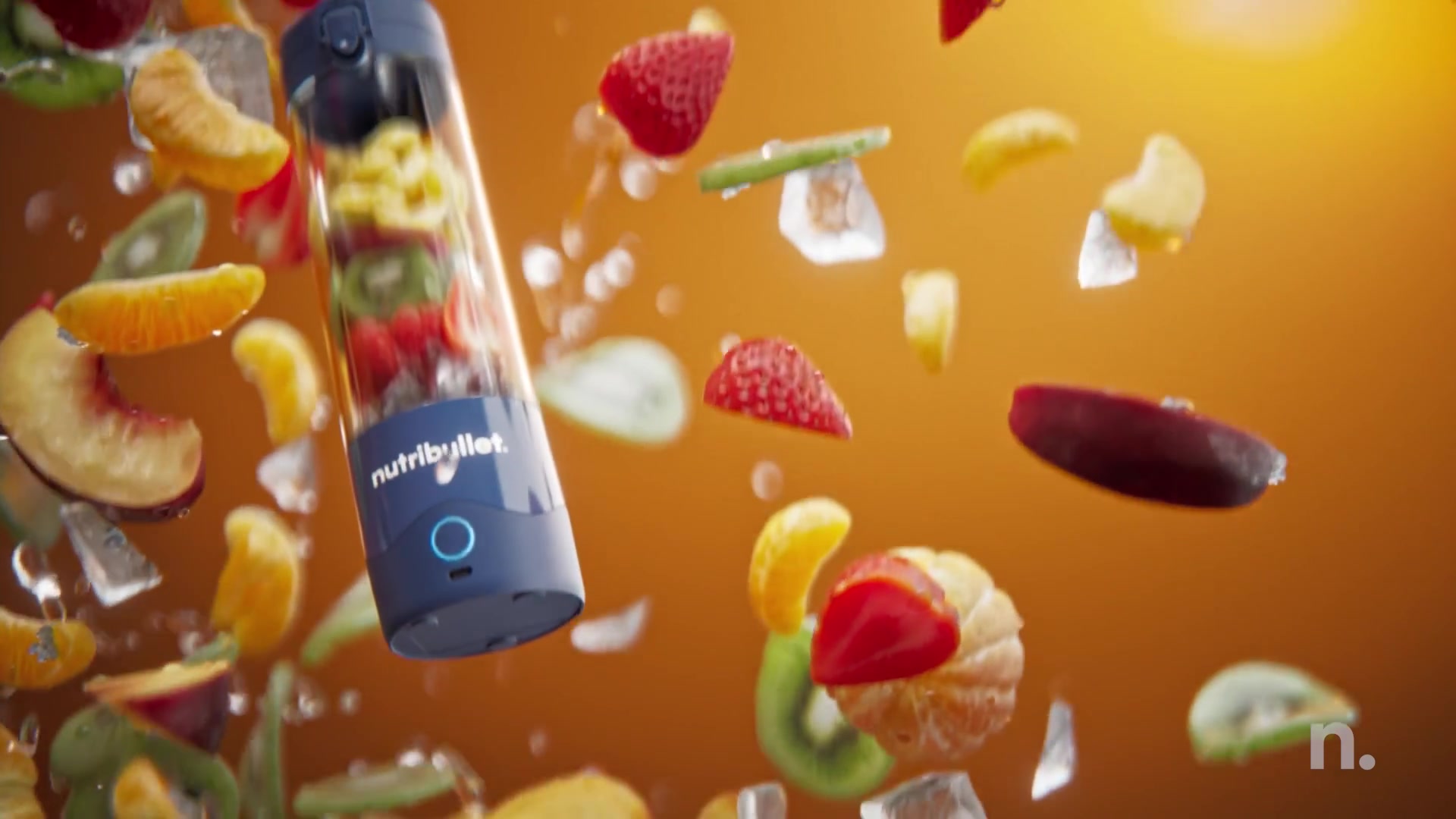 Navy Nutribullet Portable among flying fruit on orange