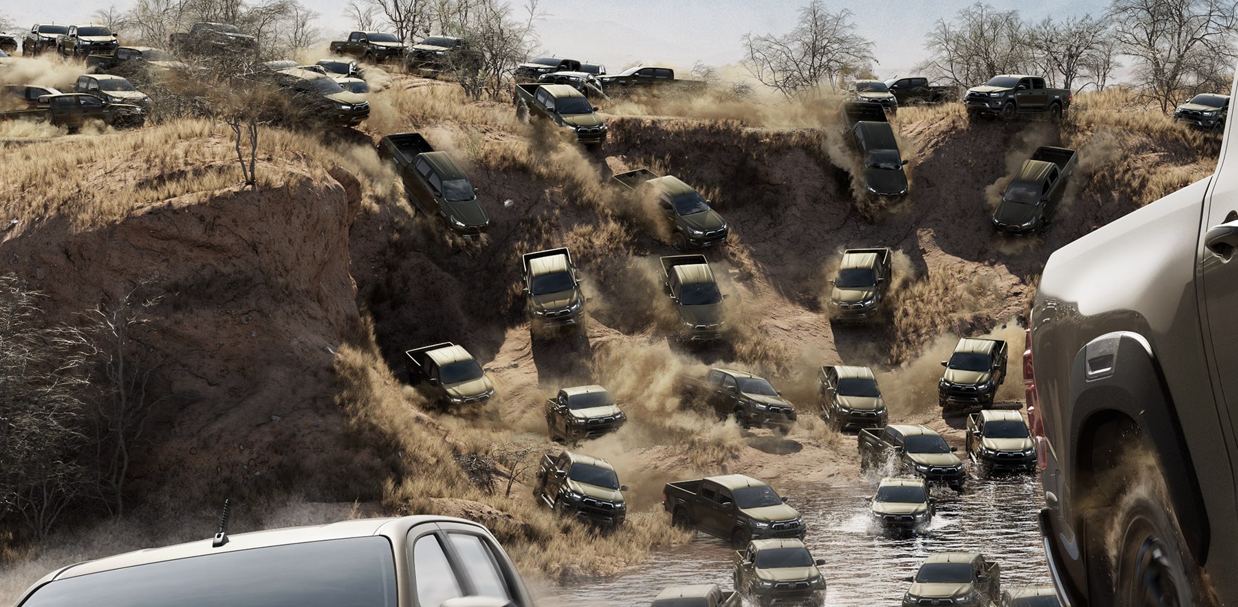 Hilux trucks pouring down a canyon and across a river