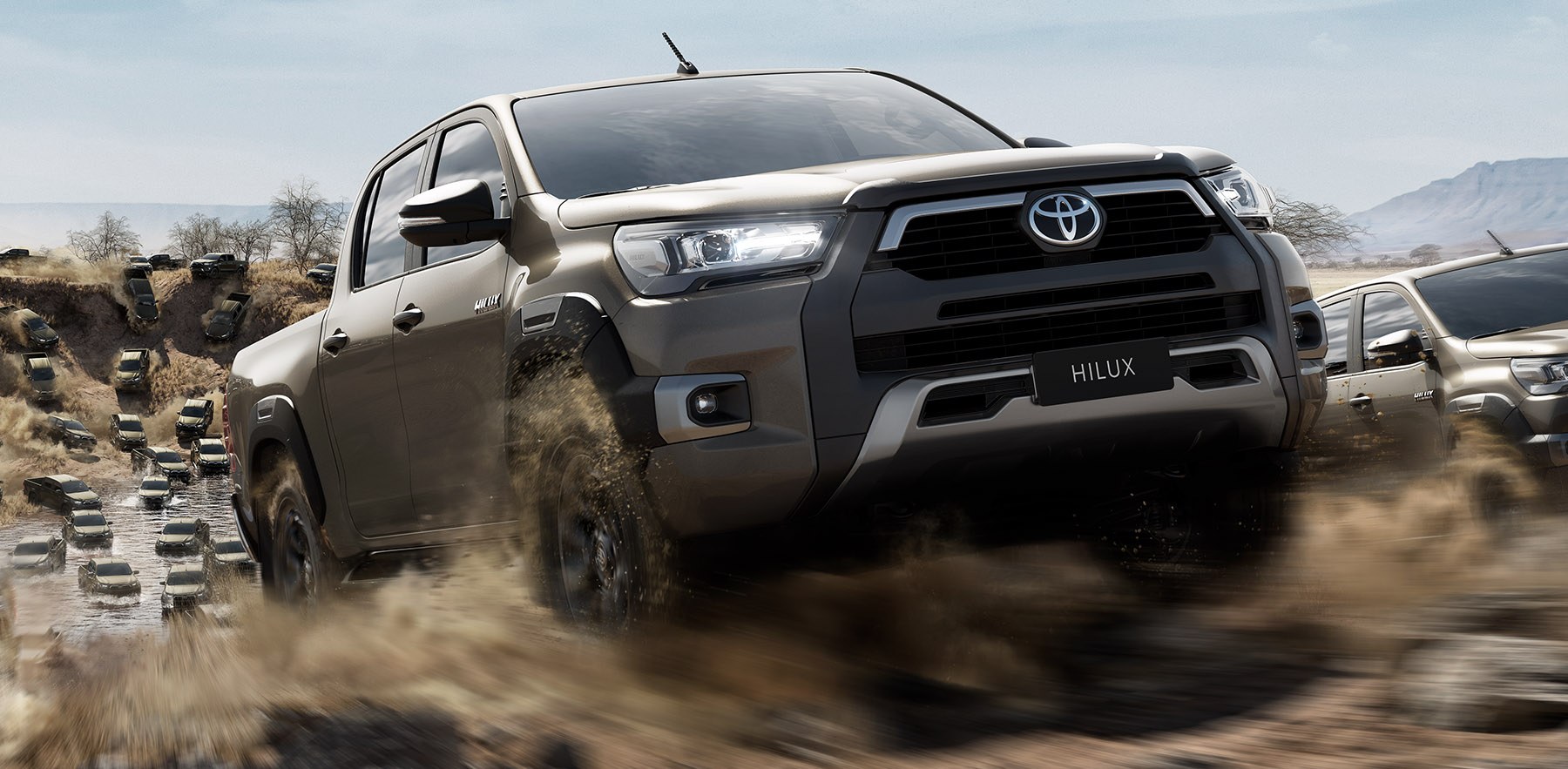 Close-up of the lead Hilux powering through dust